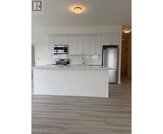 A modern kitchen with white cabinets and a large island.