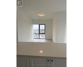A real estate listing photo of a white interior space with a large window.