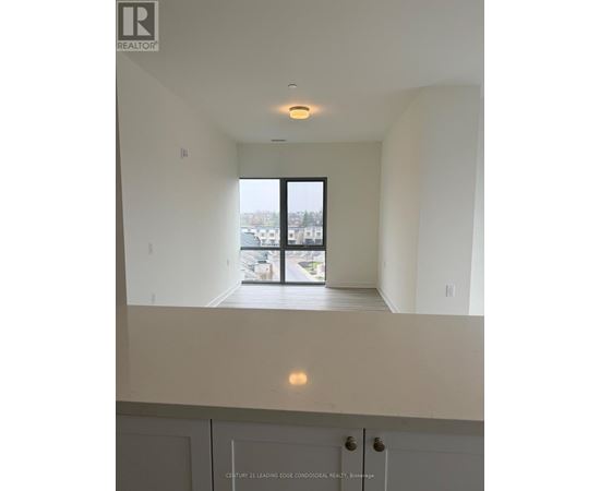 A real estate listing photo of a white interior space with a large window.