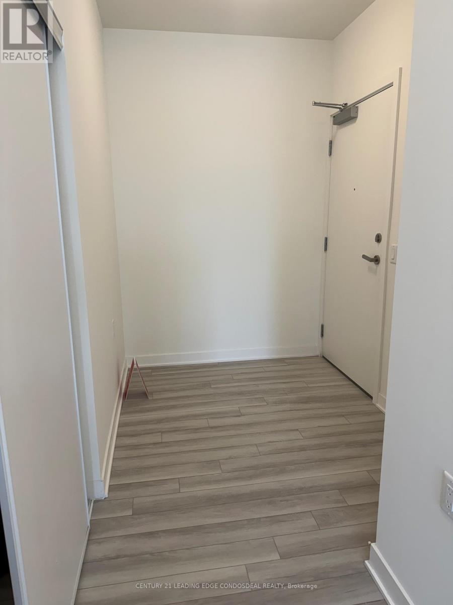 A hallway with a wooden floor and a white door.