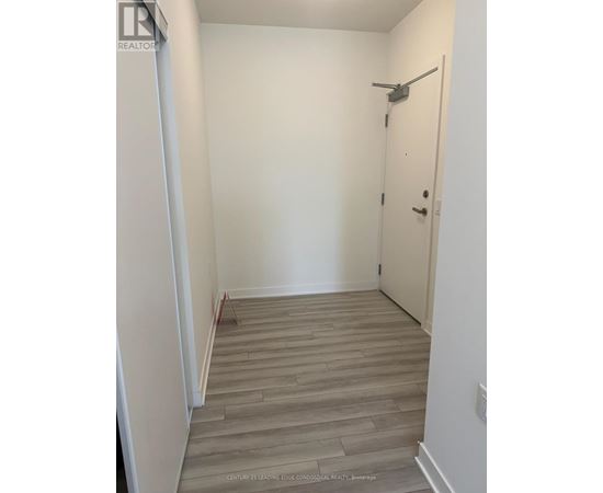 A hallway with a wooden floor and a white door.