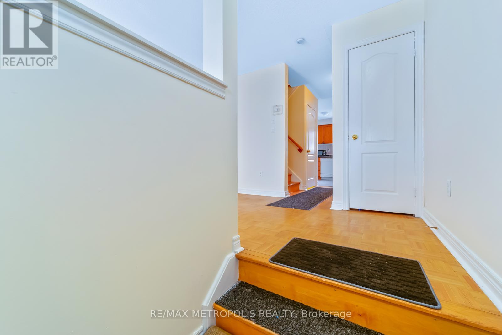A hallway with a door on the right and a mat on the floor.
