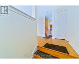 A hallway with a door on the right and a mat on the floor.