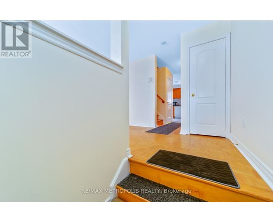 A hallway with a door on the right and a mat on the floor.