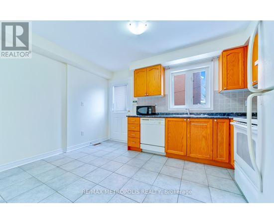 A kitchen with orange cabinets and white appliances.