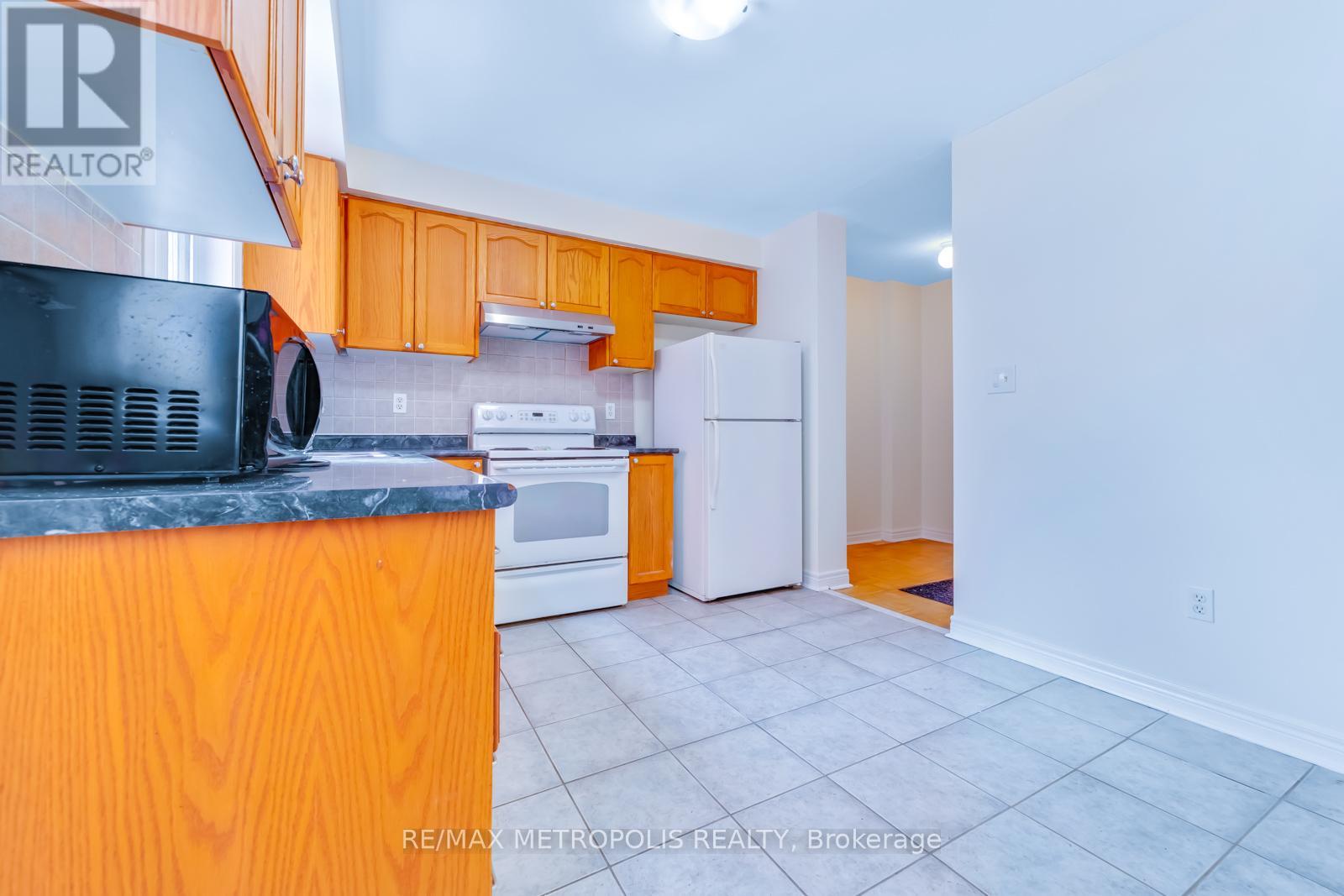A kitchen with orange cabinets and a black countertop.