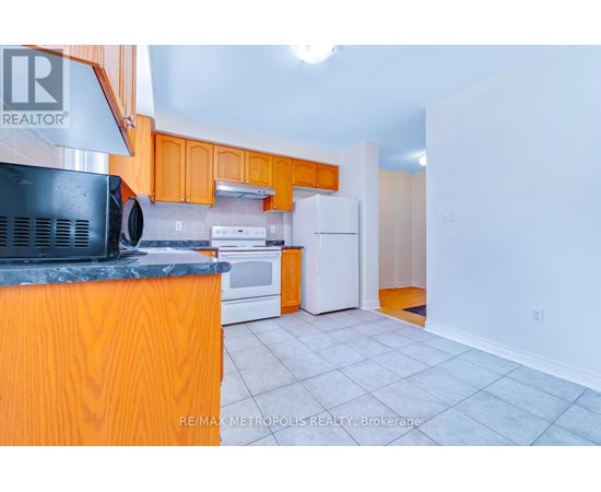 A kitchen with orange cabinets and a black countertop.