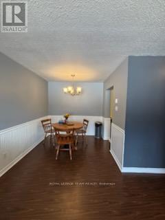 A dining room with a wooden table and chairs.