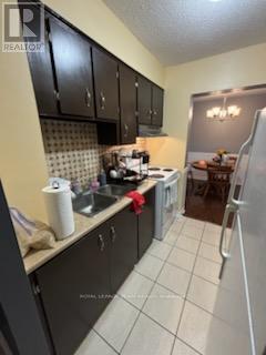 A kitchen with black cabinets and a white refrigerator.