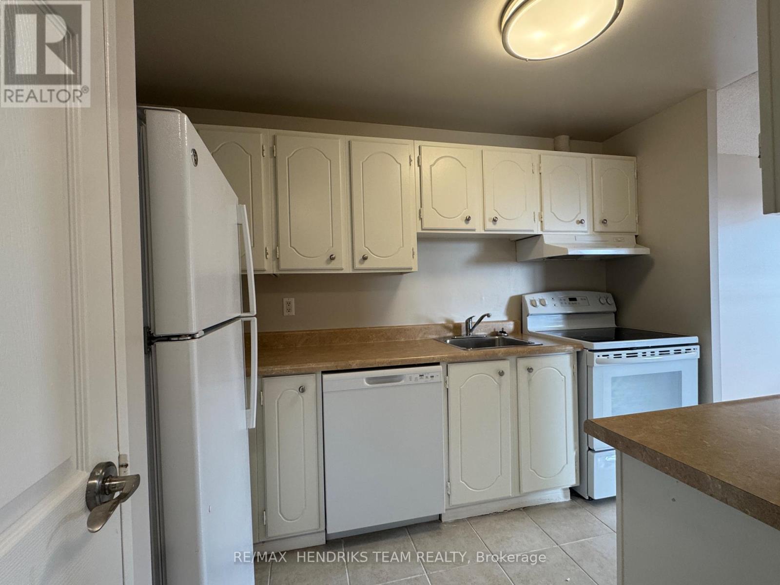 A kitchen with white appliances and cabinets.