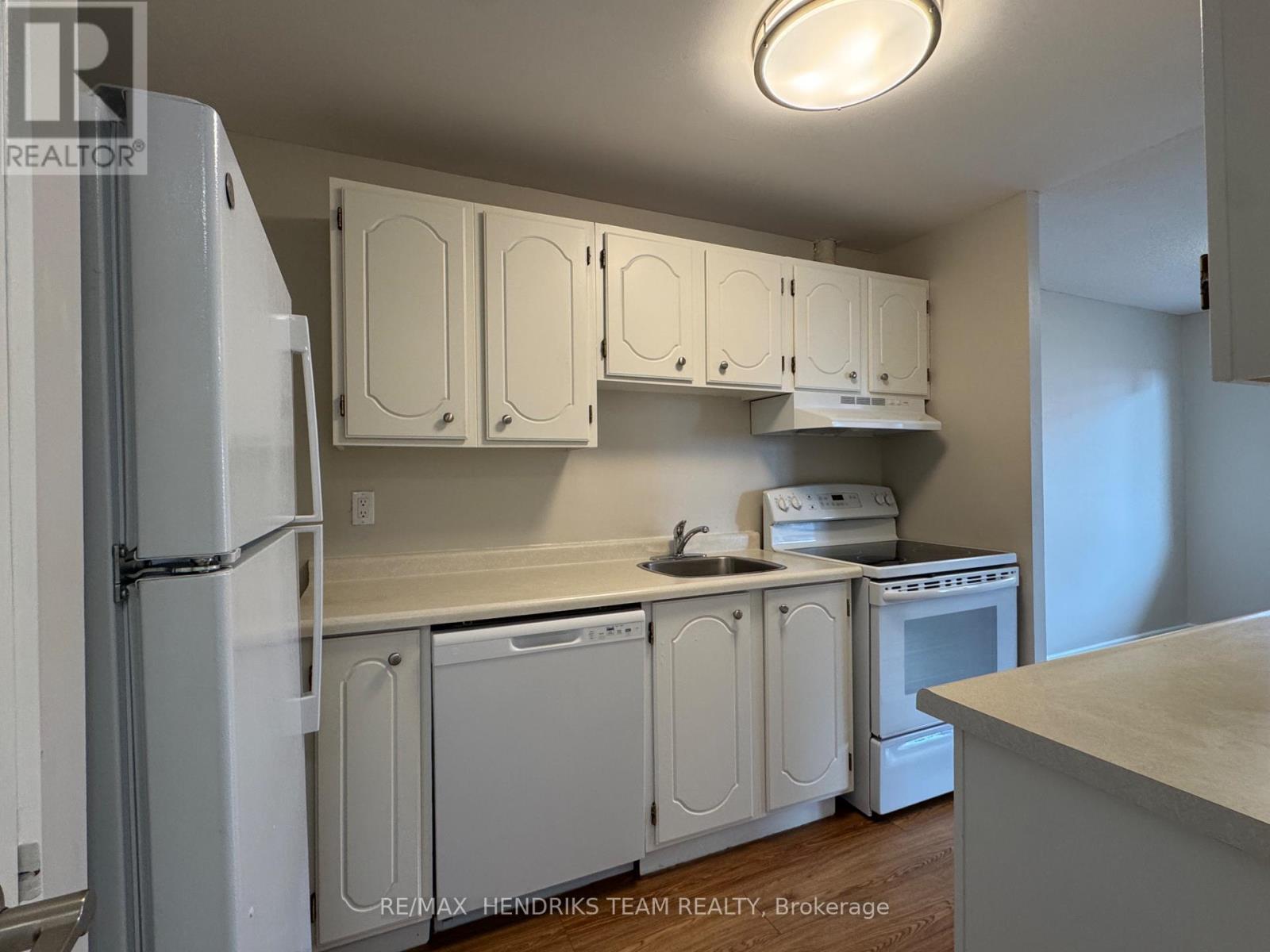 A kitchen with white cabinets and appliances.