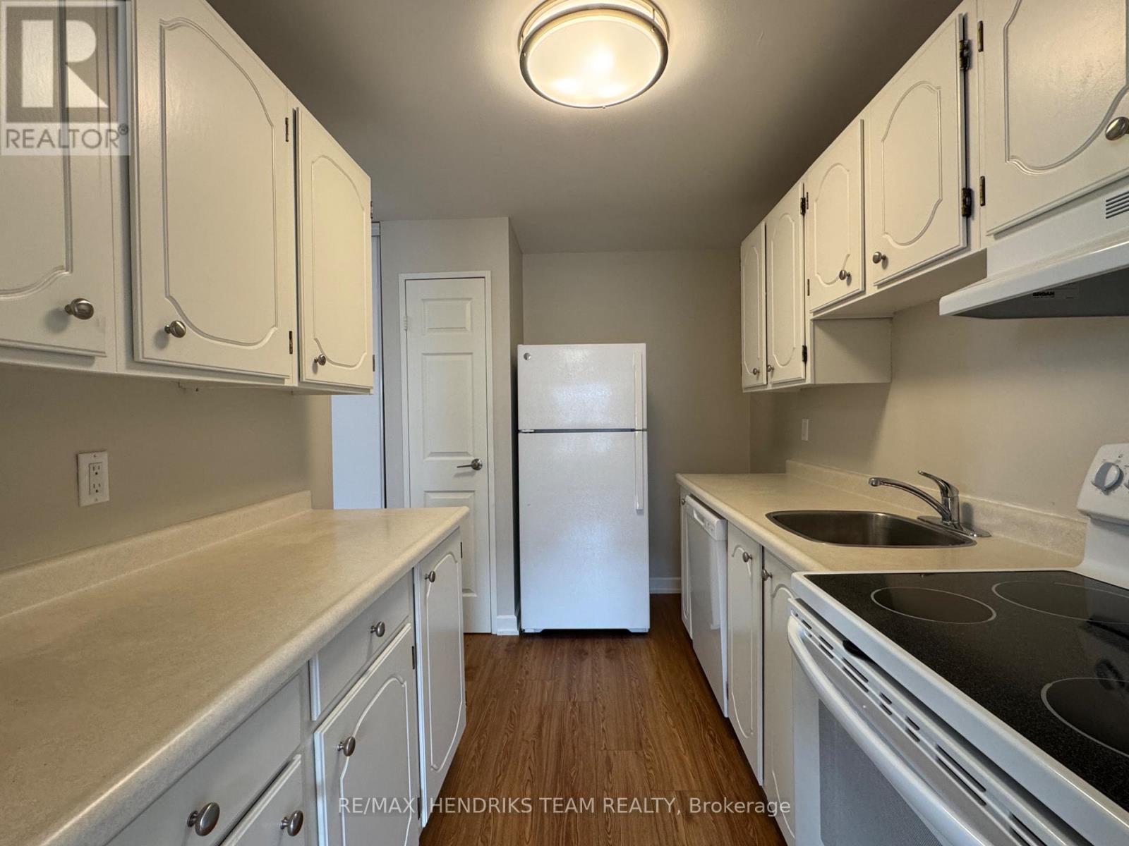 A kitchen with white cabinets and a white refrigerator.