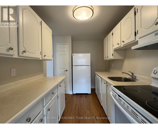 A kitchen with white cabinets and a white refrigerator.