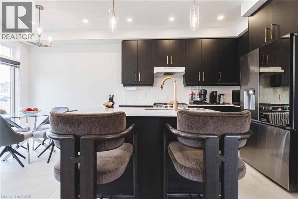 A modern kitchen with black cabinets and a center island.