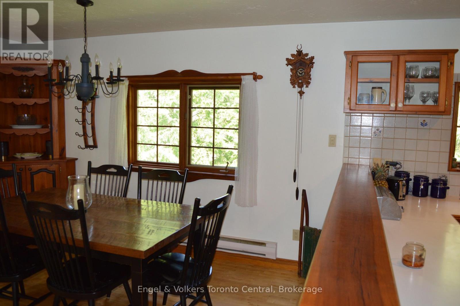 A dining room with a wooden table and chairs.