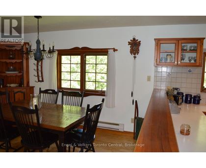 A dining room with a wooden table and chairs.