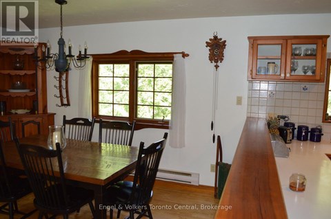 A dining room with a wooden table and chairs.