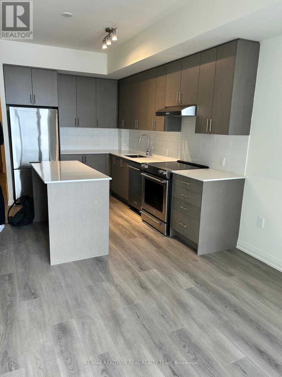 A modern kitchen with a white island and dark wood cabinets.