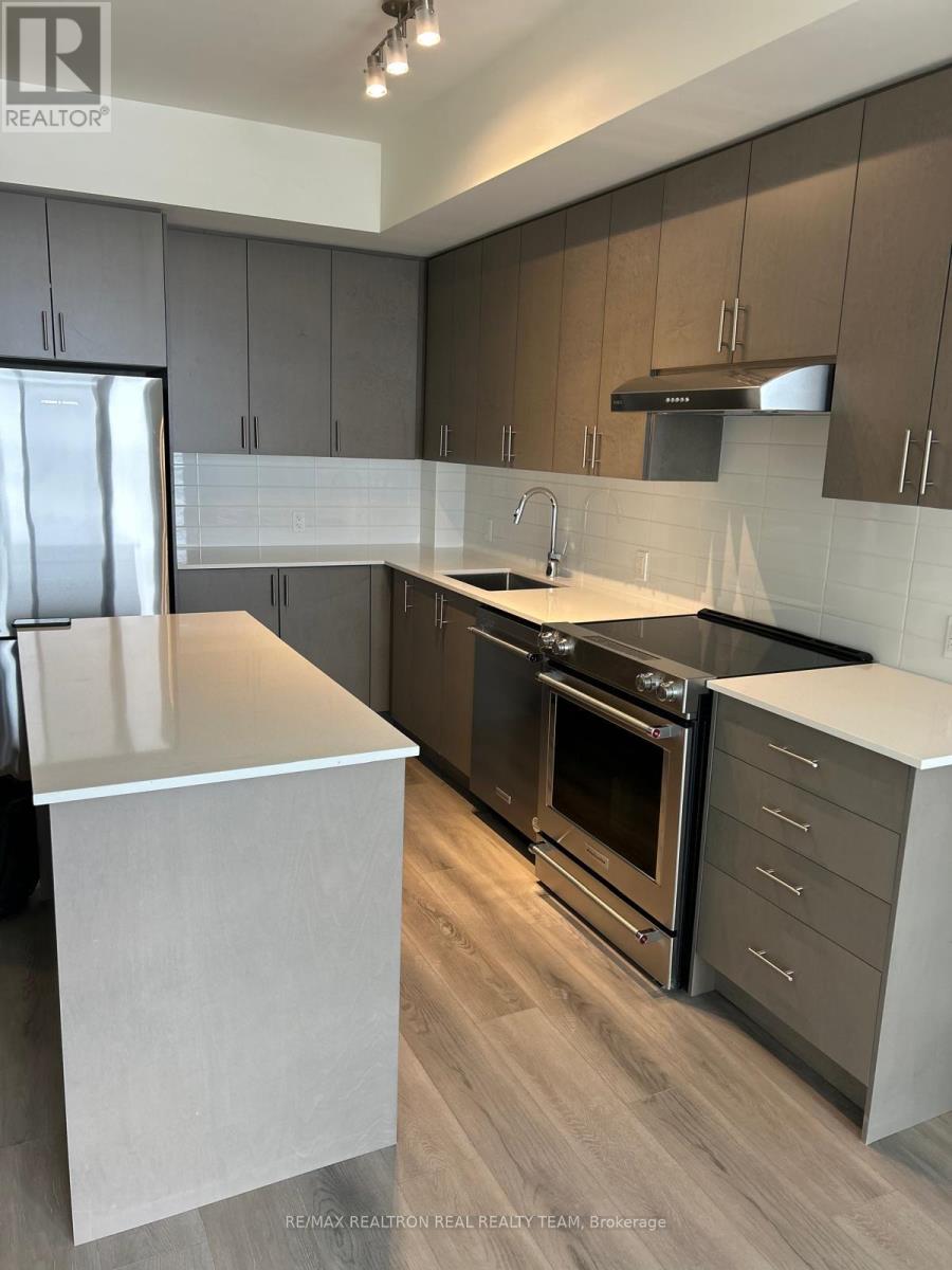 A modern kitchen with a white island and stainless steel appliances.