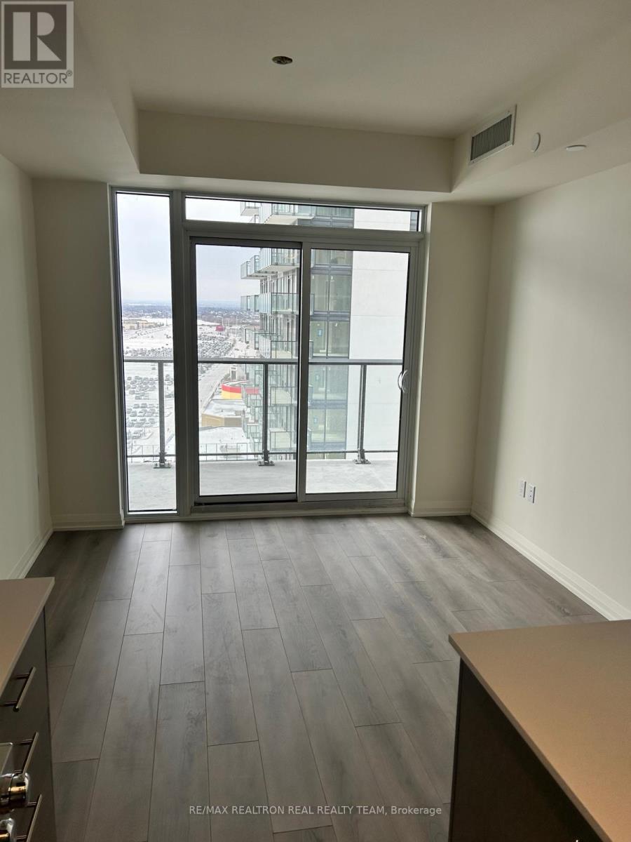A room with a view of the city through a large window.
