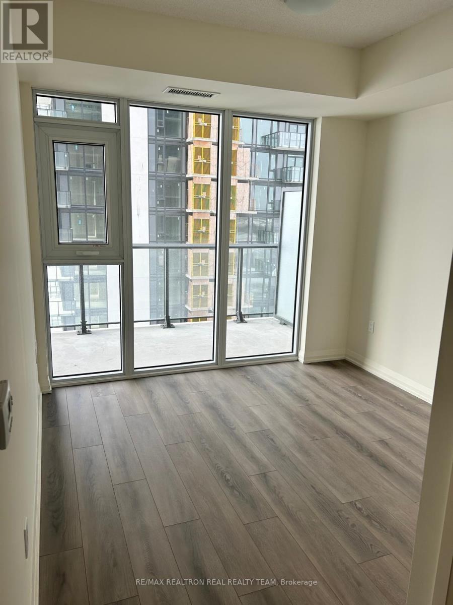 A room with a sliding glass door leading to a balcony.