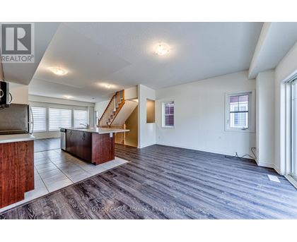 A spacious living room with a staircase leading to the upper floor.