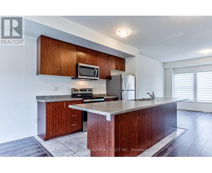 A kitchen with wooden cabinets and a granite countertop.