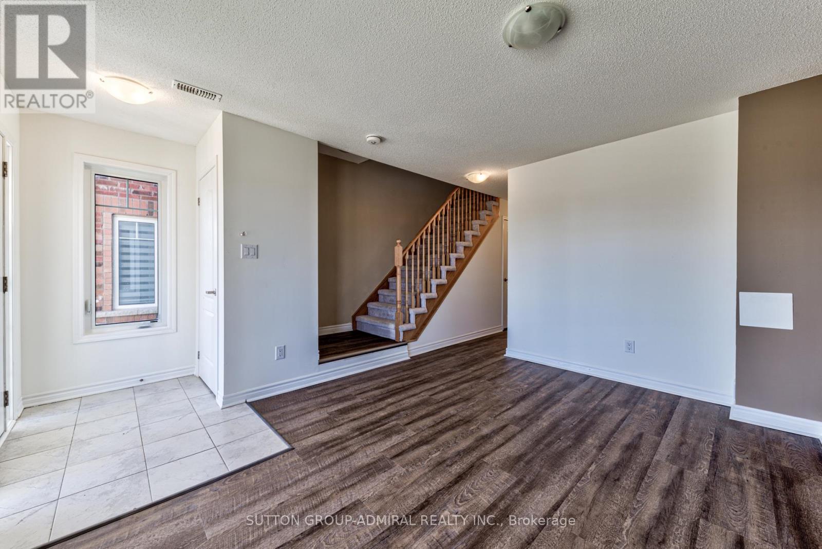 A spacious room with a staircase leading to the upper floor.