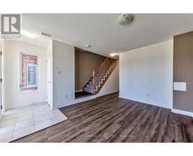 A spacious room with a staircase leading to the upper floor.
