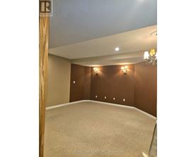 A room with a carpet floor and a chandelier hanging from the ceiling.