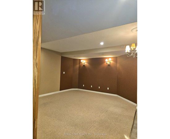 A room with a carpet floor and a chandelier hanging from the ceiling.