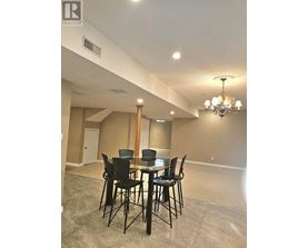 A dining room with a table and chairs.