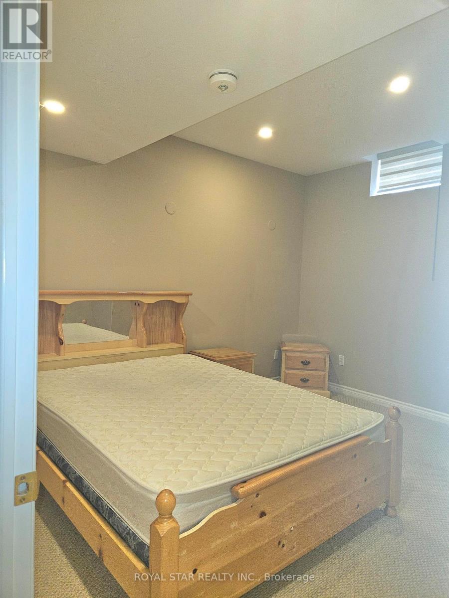 A bedroom with a bed, nightstand, and a window.