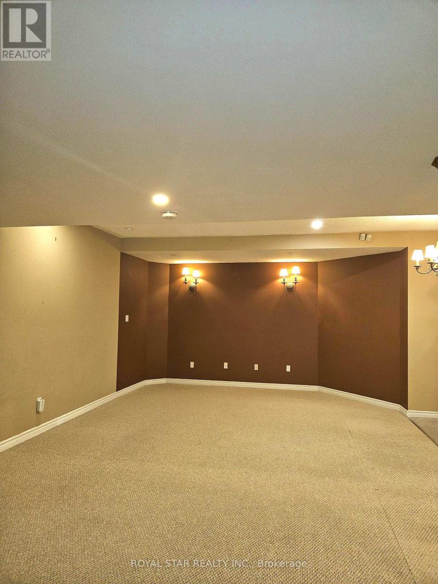 A spacious room with carpeted floor and a brown accent wall.