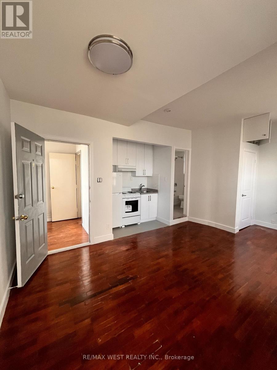 A large empty room with wood floors and white walls.