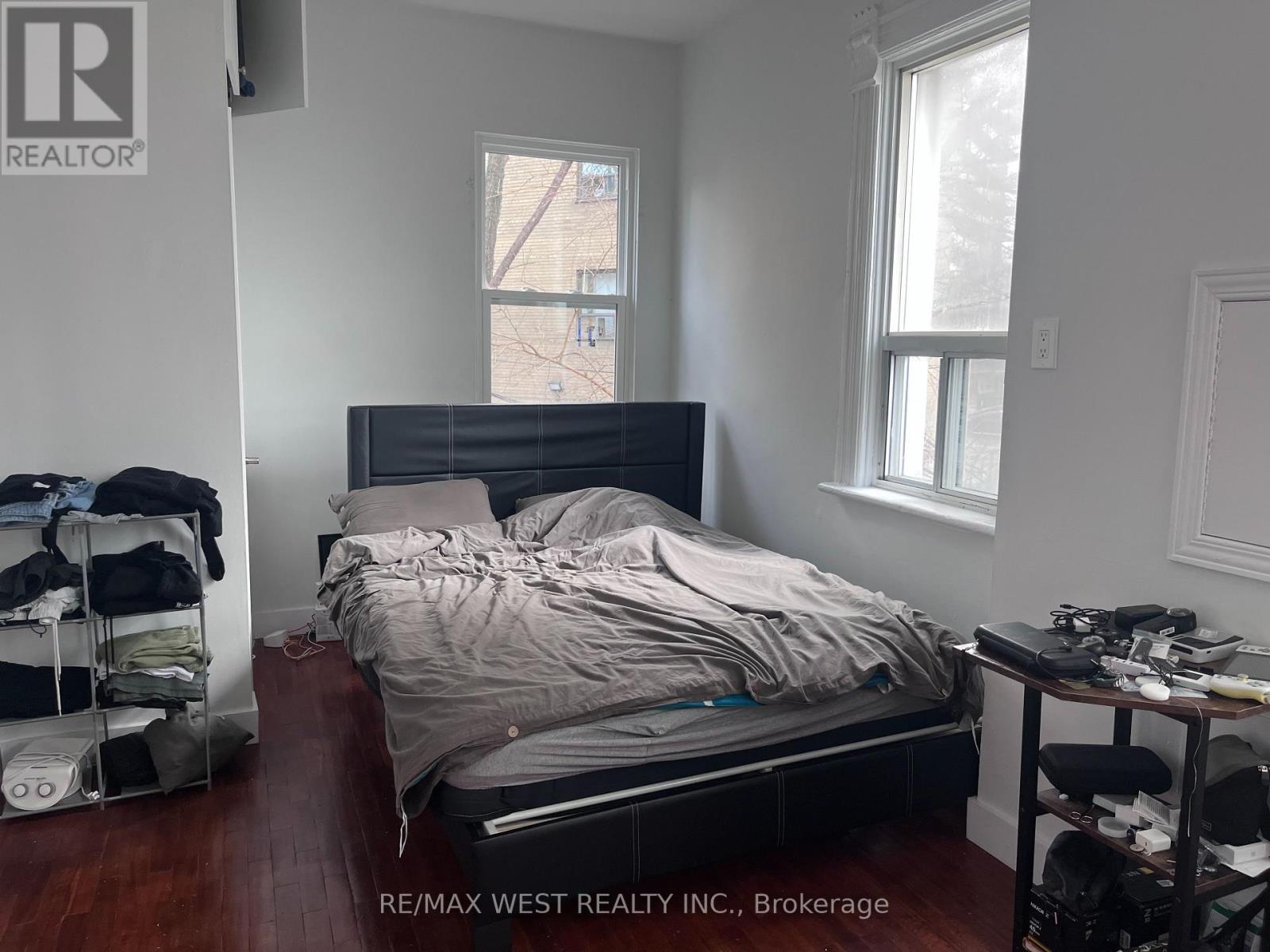 A bedroom with a bed, a desk, and a chair.
