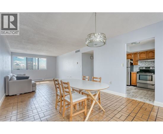 A dining room with a table and chairs.