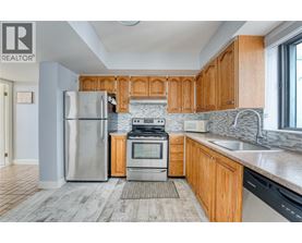 A kitchen with wooden cabinets and a stainless steel refrigerator.