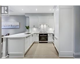 A modern kitchen with white cabinets and a marble countertop.