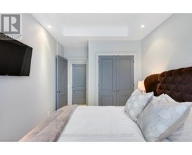 A bedroom with a large bed and a flat screen TV mounted on the wall.