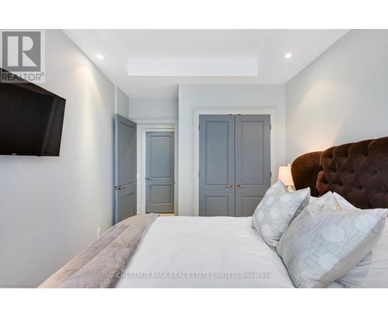 A bedroom with a large bed and a flat screen TV mounted on the wall.