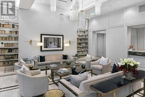 A living room with a large painting on the wall and a bookshelf filled with books.
