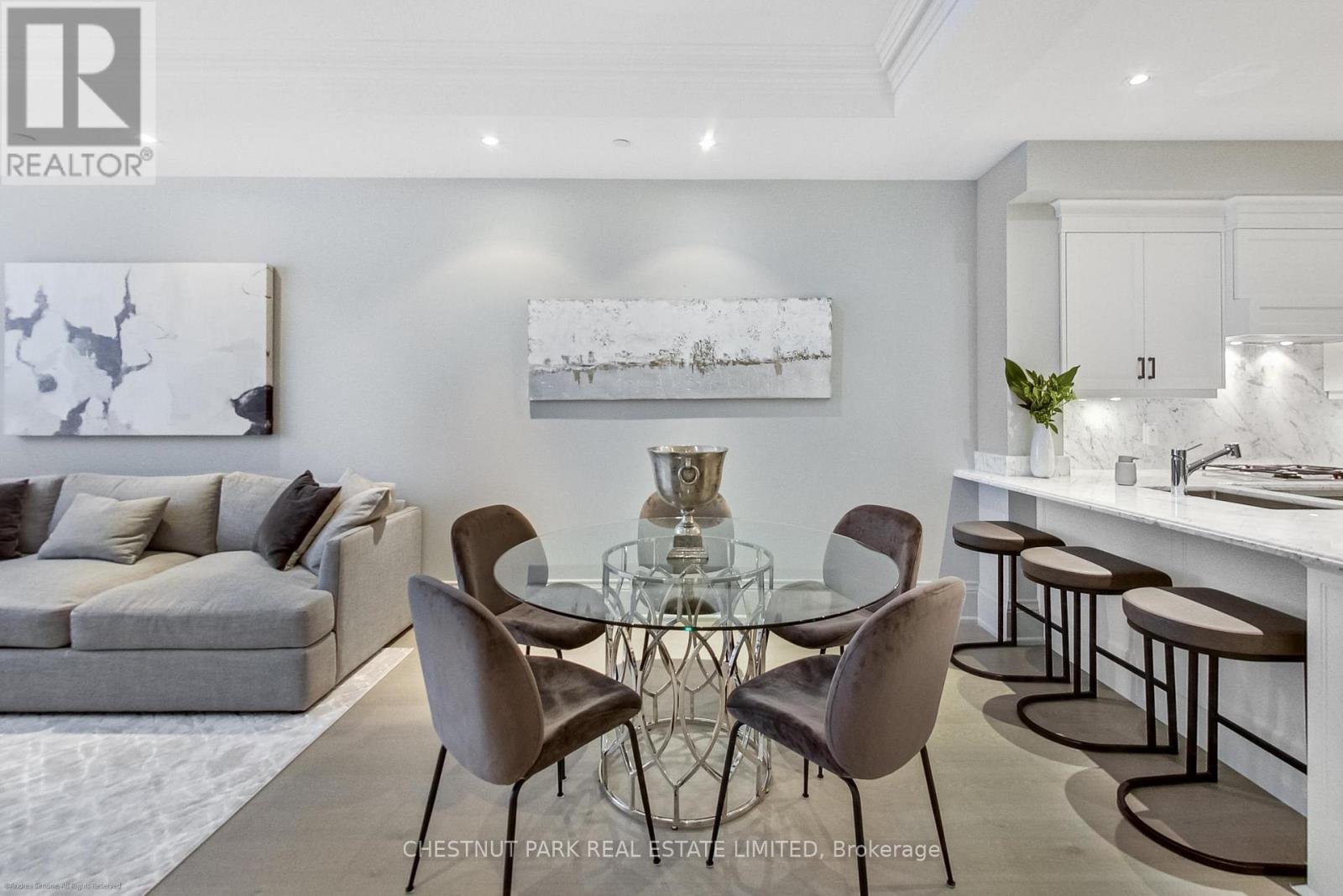 A modern dining room with a glass table and chairs.
