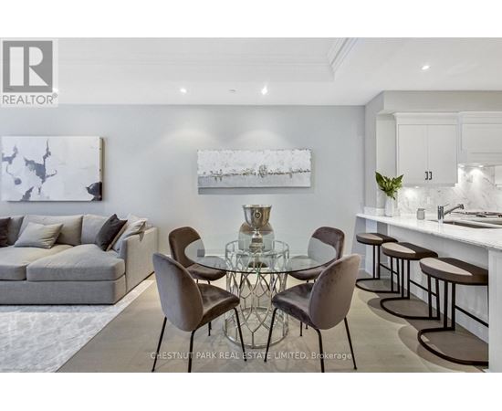 A modern dining room with a glass table and chairs.