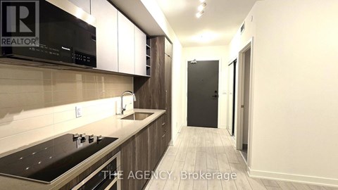 A kitchen with a black microwave and stove top oven.