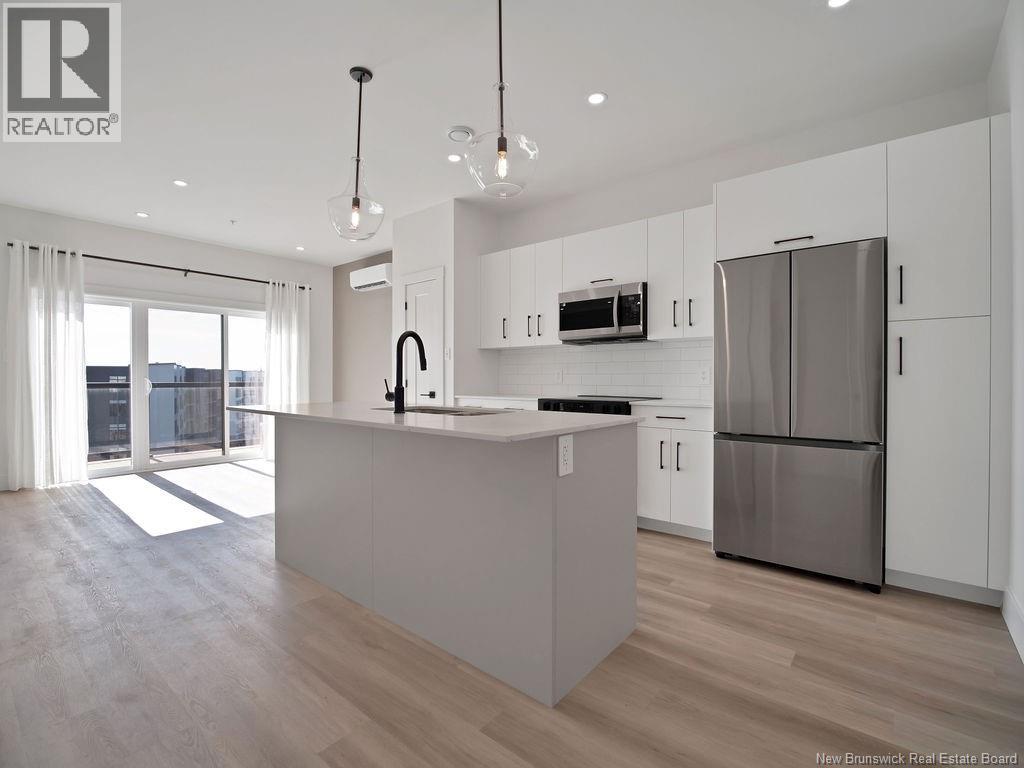 A modern kitchen with a large island and stainless steel appliances.