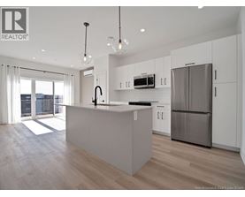 A modern kitchen with a large island and stainless steel appliances.
