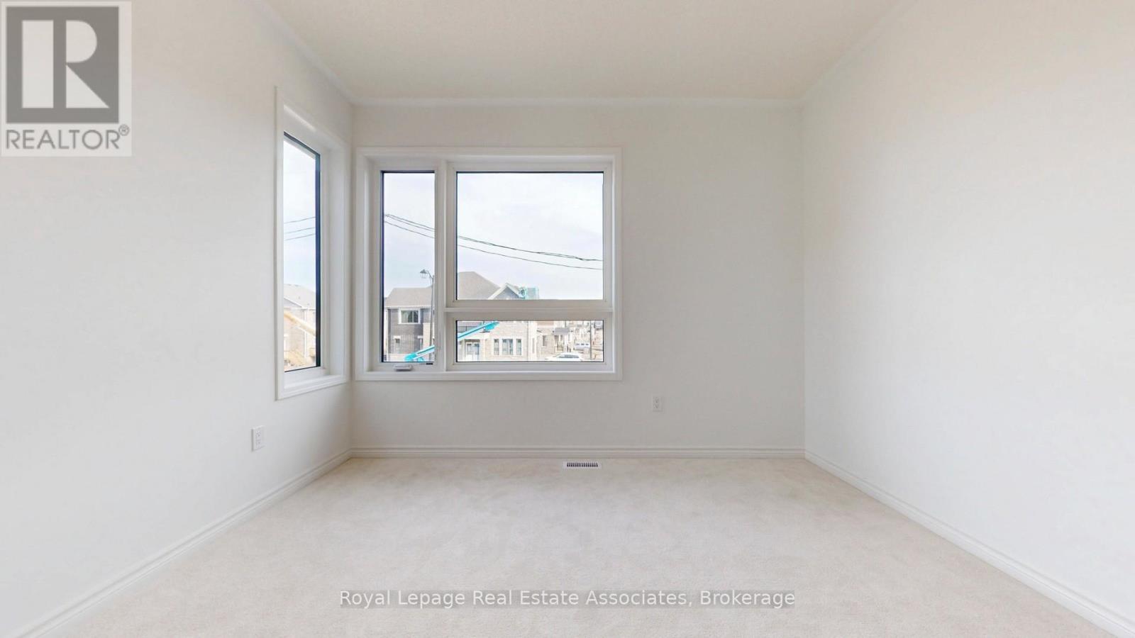 A white room with a window and a view of a building outside.