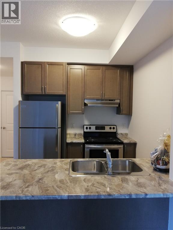 A kitchen with a blue refrigerator and a stove top oven.