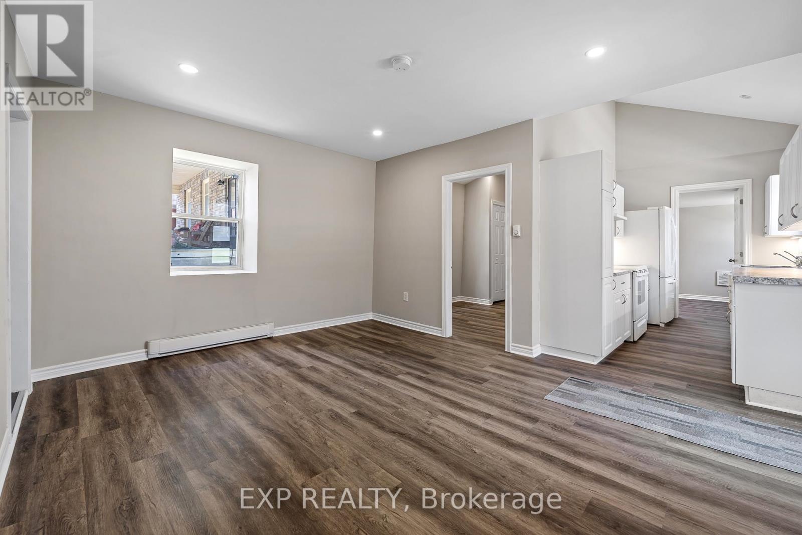 A real estate brokerage office with a large open space and wood flooring.
